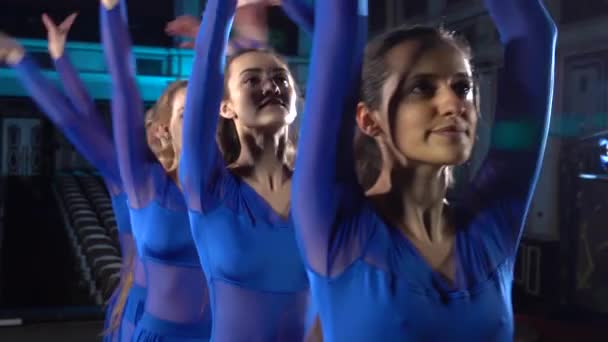 Grupo de jóvenes bailarinas hábiles bailando ballet moderno en el escenario de gran salón. Chicas mirando el auditorio. Ensayo general antes de la actuación . — Vídeo de stock