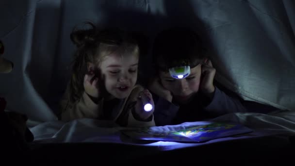 Çocuklar battaniyenin altında ilginç kitaplar okuyorlar. Yavaş çekim — Stok video