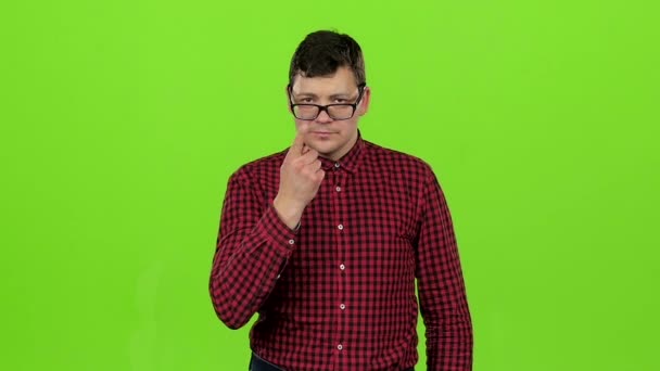 Man straightens his glasses and scoffs at people with a grin. Green screen. Slow motion — Stock Video