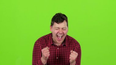 Genç adam mutlu zaferleri ile mutlu olduğunu. Yeşil ekran. Ağır çekim