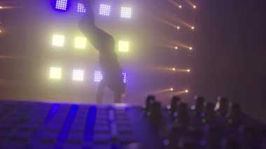 Breakdance konsepti. Genç adam kulüpte tek başına dans ediyor, neon ışıklı, dumanlı. Moda sokak kıyafeti..