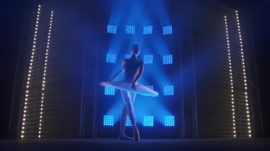 Yaratıcı kadın koreograf bir bale gösterisi hazırlıyor, dans ediyor ve mavi ışık ışınlarında çeşitli hareketler yapıyor - sanat konsepti 4k Yavaş çekim görüntüleri.