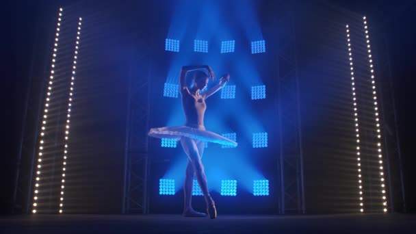 Chorégraphe féminine créative mettant en scène une performance de ballet, dansant et faisant divers mouvements dans les rayons de la lumière bleue - concept artistique 4k Slow motion footage. — Video