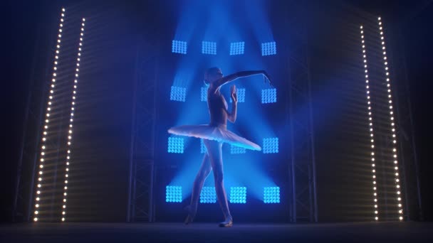 Creatieve vrouwelijke choreograaf zet ballet op, danst en doet verschillende moves in de stralen van blauw licht - kunstconcept 4k Slow motion beeldmateriaal. — Stockvideo