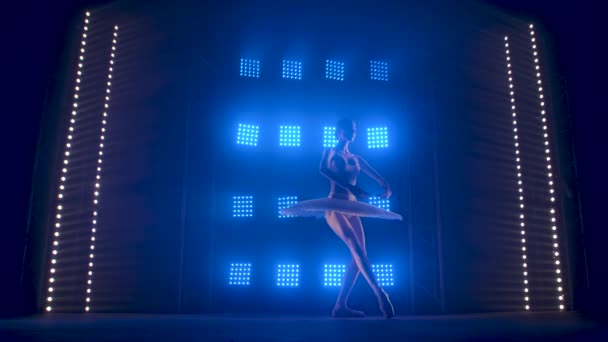 Creativa coreógrafa femenina estableciendo una actuación de ballet, bailando y haciendo varios movimientos en los rayos de luz azul - concepto de artes 4k Imágenes en cámara lenta . — Vídeo de stock