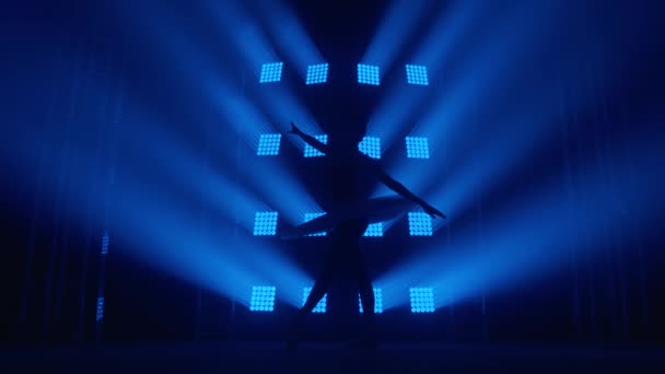 Ballerine gracieuse silhouette faisant un entraînement dans la salle de classe. Fumée dans les rayons de lumière bleue. Ballet danseur en tutu blanc, fille en pointe, tourbillons autour de vous, ralenti — Video