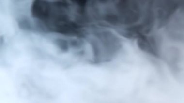 Beyaz duman siyah arka planda uzayda süzülüyor. Sis, duman, buhar, sis etkisi. Yavaş çekim
