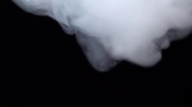 Beyaz duman siyah arka planda uzayda süzülüyor. Sis, duman, buhar, sis etkisi. Yavaş çekim