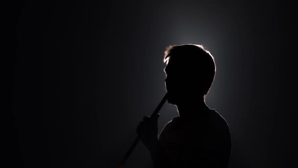 Silhouette di uomo barbuto soffia fumo quando si fuma narghilè su sfondo nero al rallentatore. Primo piano, vista profilo. — Video Stock