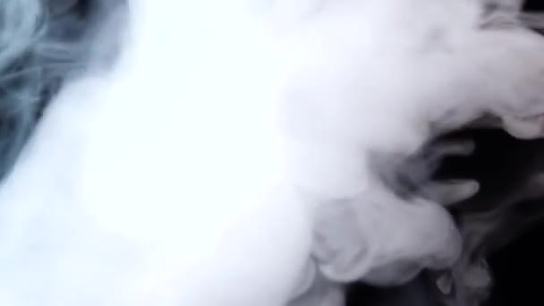 Humo blanco flotando a través del espacio sobre fondo negro. Niebla, humo, vapor, efecto niebla. Movimiento lento — Vídeo de stock