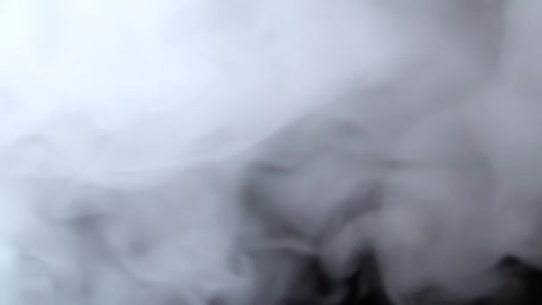 Fehér füst lebeg az űrben fekete háttérrel szemben. Köd, füst, gőz, köd hatás. Lassú mozgás. — Stock videók
