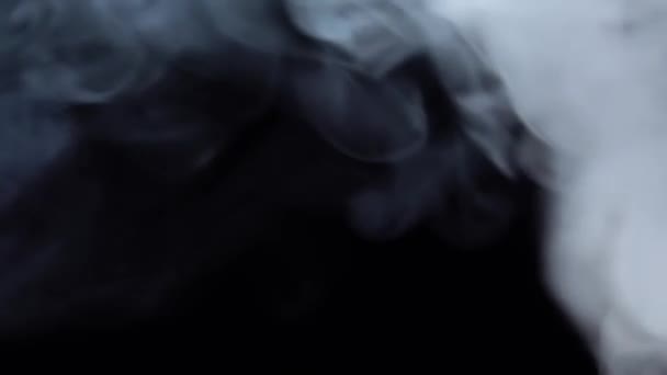 Humo blanco flotando a través del espacio sobre fondo negro. Niebla, humo, vapor, efecto niebla. Movimiento lento — Vídeos de Stock