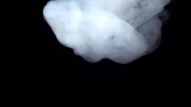 Fumée blanche flottant dans l'espace sur fond noir. Brume, fumée, vapeur, effet brouillard. Mouvement lent