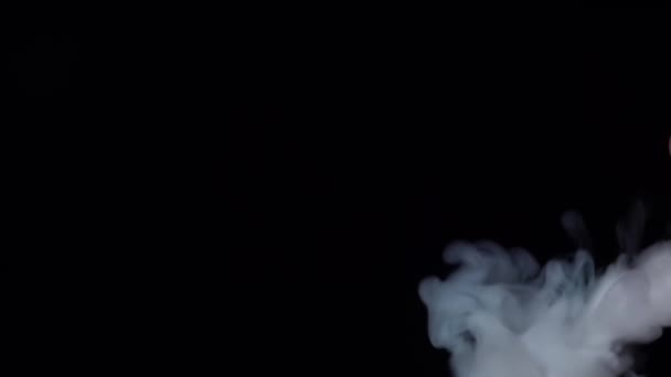 Humo blanco flotando a través del espacio sobre fondo negro. Niebla, humo, vapor, efecto niebla. Movimiento lento — Vídeo de stock