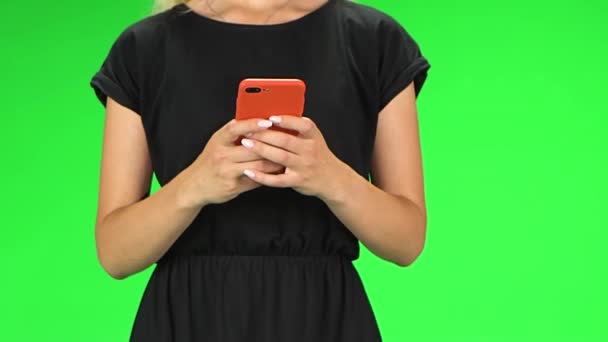 Meisje met rode telefoon in haar handen tijdens het lopen, close-up. Groen scherm. Langzame beweging — Stockvideo