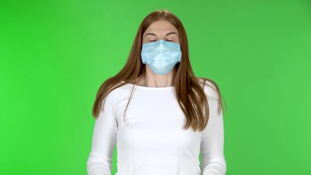 Retrato de menina bonita em máscara protetora médica olhando para preocupações câmera e dobras palmas para o outro . — Vídeo de Stock