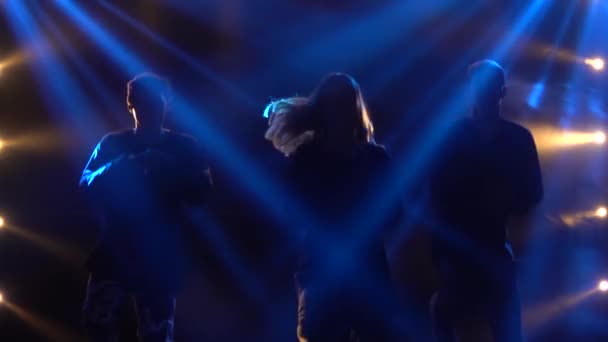 Silhouetten van een getalenteerde groep jonge hiphopdansers. Hip hop straat dans op een podium in donkere studio met rook en neon verlichting. Dynamische lichteffecten. Creatieve vaardigheden. Langzame beweging. — Stockvideo