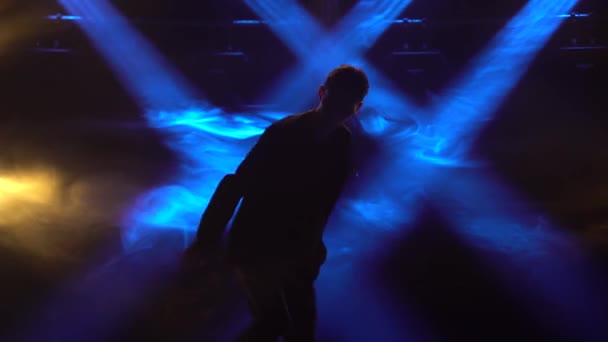 Silhouet van een getalenteerde jonge hiphopdanser. Hip hop straat dans op een podium in donkere studio met rook en neon verlichting. Dynamische lichteffecten. Creatieve vaardigheden. — Stockvideo