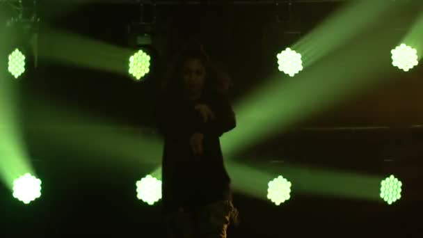 才能ある少女ヒップホップダンサーのシルエット。煙とネオンの照明と暗いスタジオでステージ上のヒップホップストリートダンス。ダイナミックな照明効果。創造力. — ストック動画