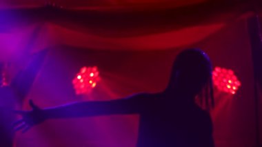 Karanlık bir stüdyoda duman ve neon ışıklarla dans eden Joan of Arc 'ın silueti. Altın elbiseli ve başlıklı, kılıçlı, parlak, genç bir kadın. Dinamik neon ışık efektleri. Lüks.