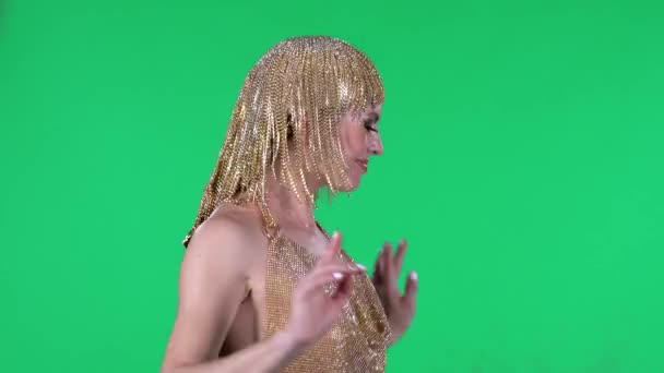 Portrait of beautiful young women is dancing. A bright makeup gold dress and headdress on a green screen in the studio. Side view. — Stock Video