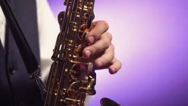 Músico profesional tocando teclas tocando saxofón dorado brillante en el escenario. Estudio oscuro con humo e iluminación de neón. De cerca.. — Vídeo de stock