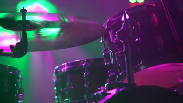 Drumstel en borden op het podium in fel neon licht. Donkere studio met rook en dynamische neonverlichting. Sluiten.. — Stockvideo