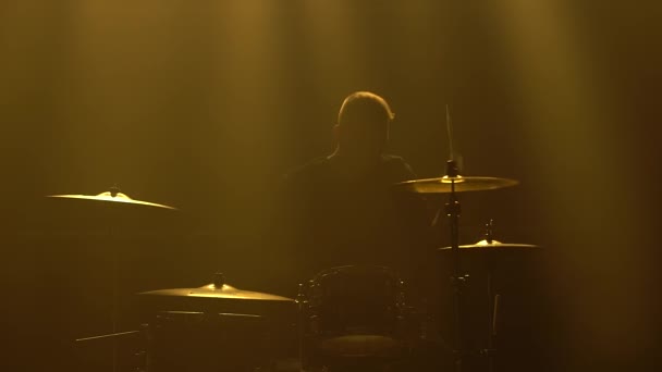 Silhouette baterista tocando en el kit de batería en el escenario en un estudio oscuro con humo e iluminación de neón. Banda vocal y musical. Primer plano. — Vídeos de Stock