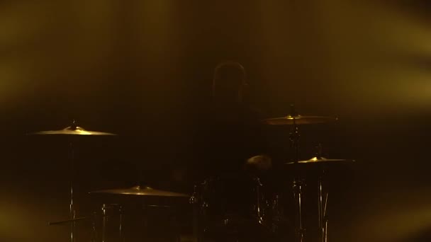 Baterista de silhueta tocando bateria no palco em um estúdio escuro com fumaça e iluminação de néon. Efeitos de iluminação de néon dinâmico. Performance vocal e banda musical. Close-up . — Vídeo de Stock