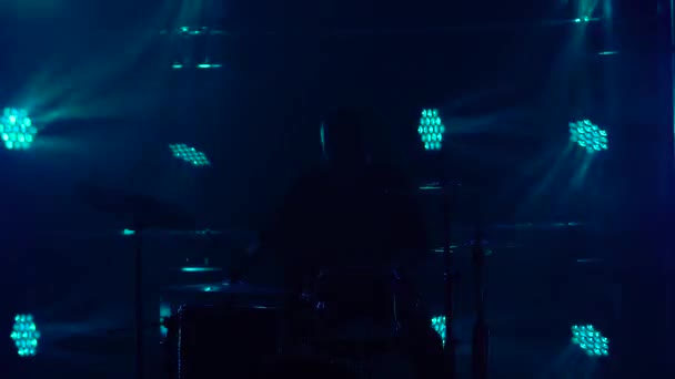 Барабанщик Силуетт грає на ударній установці на сцені в темній студії з димом і неоновим освітленням. Динамічні неонові світлові ефекти. Виконання вокалу і музичного гурту. Підсумок.. — стокове відео