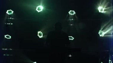 Karanlık stüdyoda, sentezleyici piyano klavyesinde neon ışıkla çalan müzisyen silueti. Dinamik neon ışık efektleri. Performans vokal ve müzik grubu.
