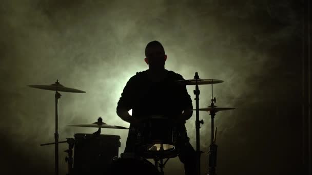 Барабанщик Силуетт грає на ударній установці на сцені в темній студії з димом і неоновим освітленням. Виконання вокалу і музичного гурту. Підсумок.. — стокове відео