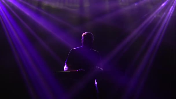 Muzikant silhouet spelen op synthesizer piano toetsenbord in donkere studio met neon verlichting. Dynamische neonverlichting effecten. Optreden vocale en muzikale band. — Stockvideo