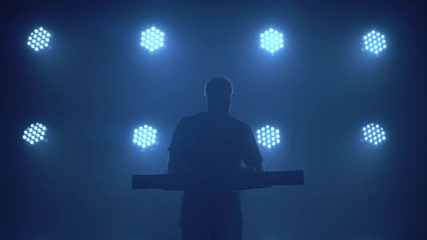 Silueta de músico tocando en sintetizador teclado de piano en estudio oscuro con iluminación de neón. Banda vocal y musical de performance. — Vídeos de Stock