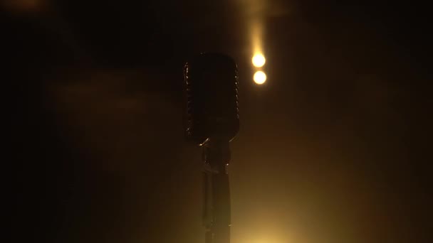 Microphone classique rétro chromé dans un studio sombre avec éclairage fumé et néon. Effet lumineux néon dynamique. Gros plan.