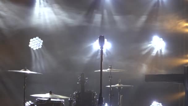 Klassisches Retro-Chrom-Mikrofon und E-Gitarre zusammen mit Schlagzeug und Piano-Synthesizer-Keyboard auf der Bühne im dunklen Studio mit Rauch und Neonlicht. Dynamische Neonlichteffekte. Nahaufnahme — Stockvideo