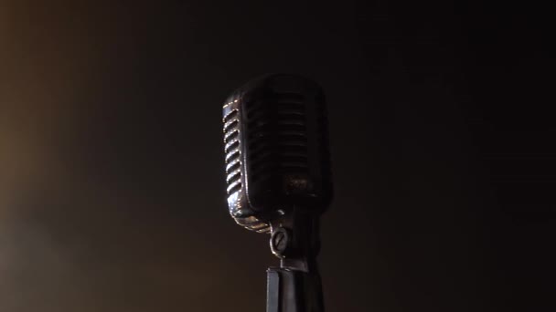 Classic retro chrome microphone in dark studio with smoke and neon lighting. Dynamic neon lighting effects. Close up. — Stock Video