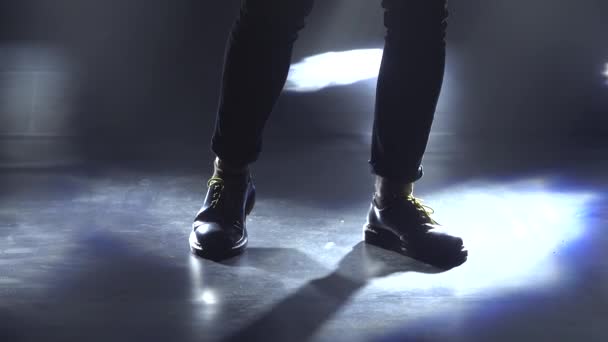 Silhouet van de jongeman die de elektrische gitaar op het podium bespeelt in een donkere studio met rook en neonverlichting. Dynamische neonverlichting effecten. Optreden vocale en muzikale band. Filmen van de — Stockvideo