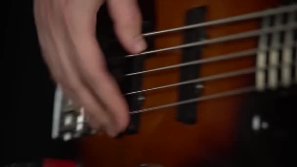 Músico profesional tocando la guitarra eléctrica en un estudio oscuro con humo e iluminación de neón. El primer plano de los dedos de un tipo tocando movió los hilos de un musical. Efectos dinámicos de iluminación de neón. — Vídeo de stock