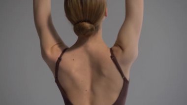 Beyaz etekli ve sivri uçlu ayakkabılı genç ve güzel balerin prova yapıyor. Dans stüdyosu dersi. Arka plan kapat.