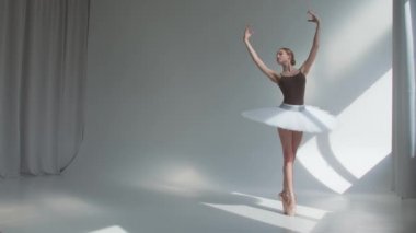 Dişi dansçı, bale egzersizlerini sahne elbisesiyle ve arkası açık yapar. Dans provaları geniş ve aydınlık stüdyoda yapılıyor..