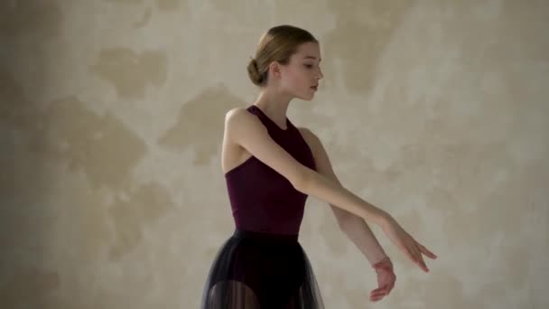 Graziosa ballerina in una lunga gonna nera balla in una scuola di danza classica. Close up sullo sfondo di una parete luminosa. — Video Stock