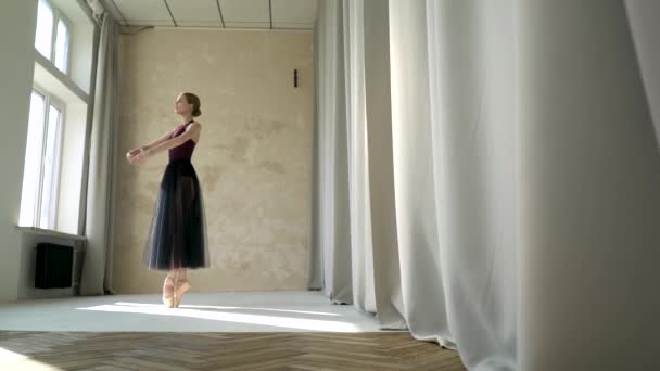 예쁜 발레 댄서가 무대 의상을 입고 댄스 스튜디오 수업을 하죠. 이른 아침밝은 조명을 받은 스튜디오에서 촬영 한 뒤 배경에 파노라마 창을 들고 찍은 사진. — 비디오