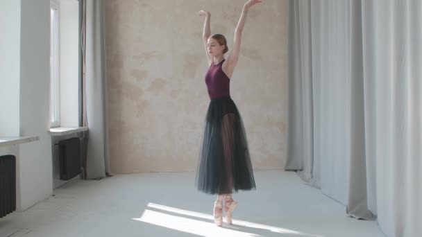 Realización de una bailarina frágil sobre el fondo de grandes ventanas y cortinas panorámicas. Filmado en un estudio tipo loft bañado por la luz del día. — Vídeos de Stock