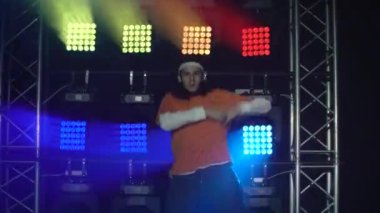 Stüdyoda modern dans gösterisi yapan profesyonel hip-hop dansçısının portresi hareketlere yoğunlaşmıştı. Halk ve gençlik kültürü kavramı. Dinamik çok renkli ışıklandırma efektleri. Kapat..