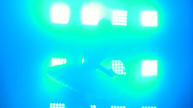 Gölgede dans eden zarif balerin, arka planda mavi ışık ve dumanla klasik balerin unsurları. Kapat..