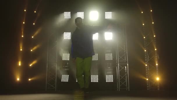 Dançarino hip hop jovem na moda em uma máscara médica protetora. Hip hop dança de rua em um palco em estúdio escuro com fumaça e iluminação de néon. Conceito de estilo de vida saudável e ativo. — Vídeo de Stock