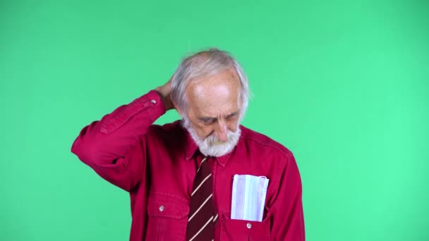 Портрет счастливого старика 70-х годов о чем-то думает, а потом приходит к нему идея, изолированная на зеленом фоне. — стоковое видео