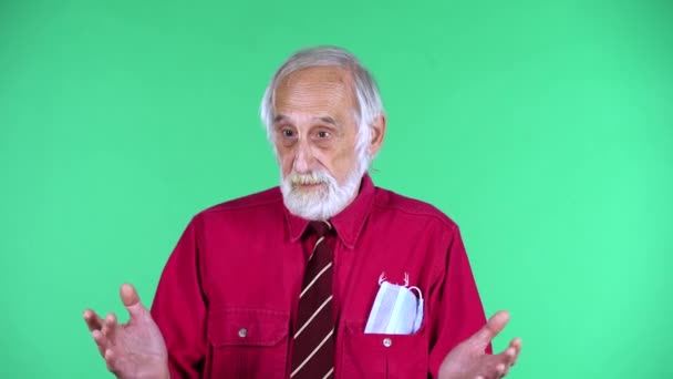 Portræt af glade gamle mand 70 'erne kommunikerer med nogen, isoleret over grøn baggrund. – Stock-video