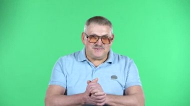 Yaşlanmış bir adamın portresi biriyle iletişim kuruyor, yeşil arka planda izole edilmiş..